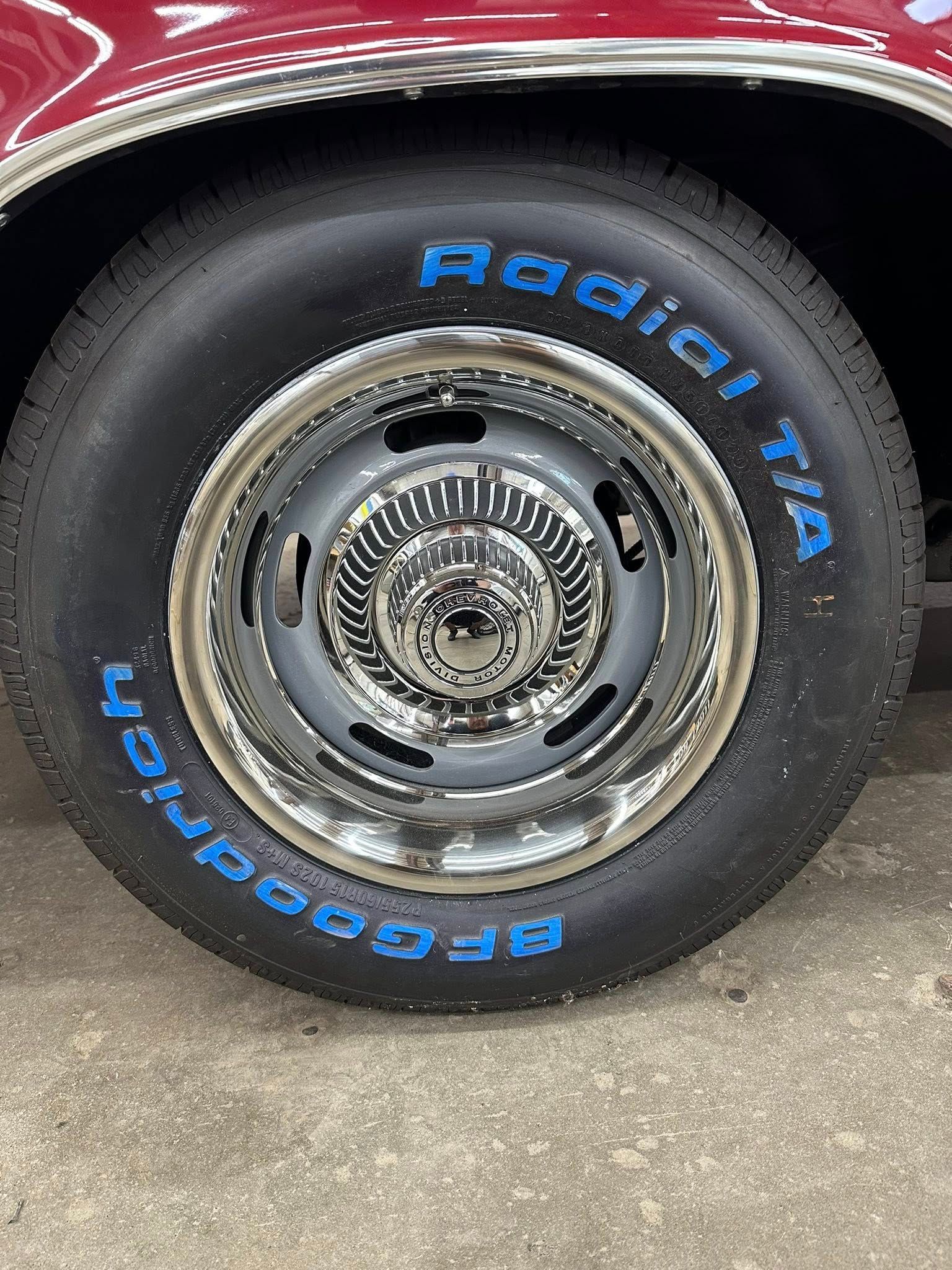 Close-up of a classic car wheel with a chrome hubcap and blue-lettered BFGoodrich Radial T/A tire.
