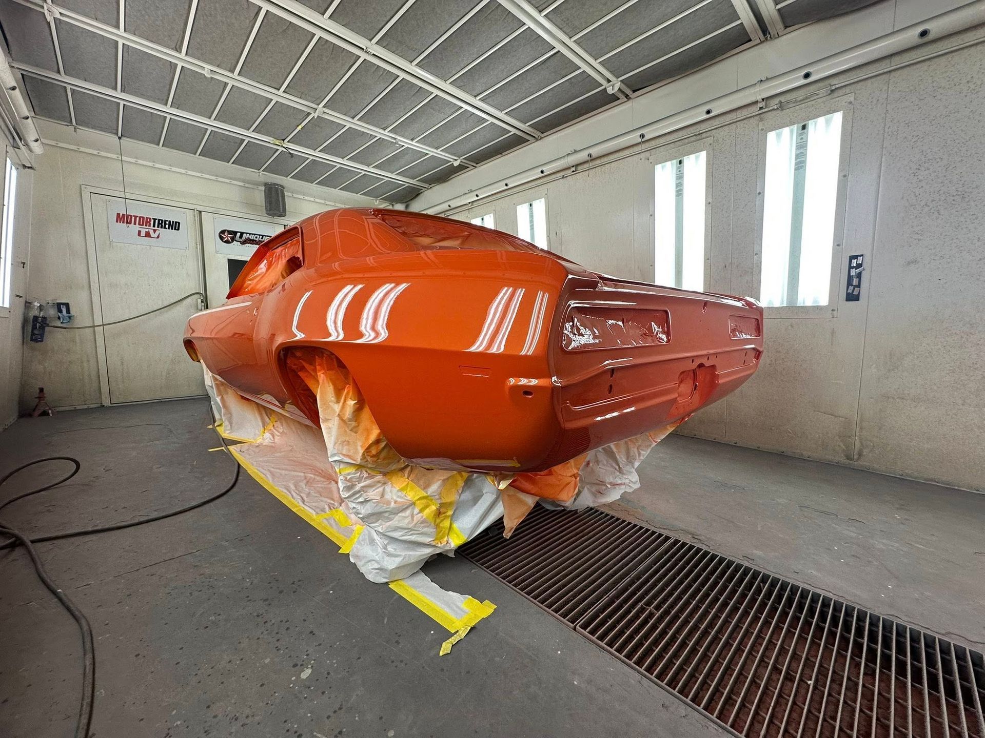 Orange classic car in a paint booth.