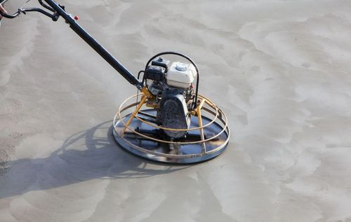 Power trowel smoothing wet concrete surface.