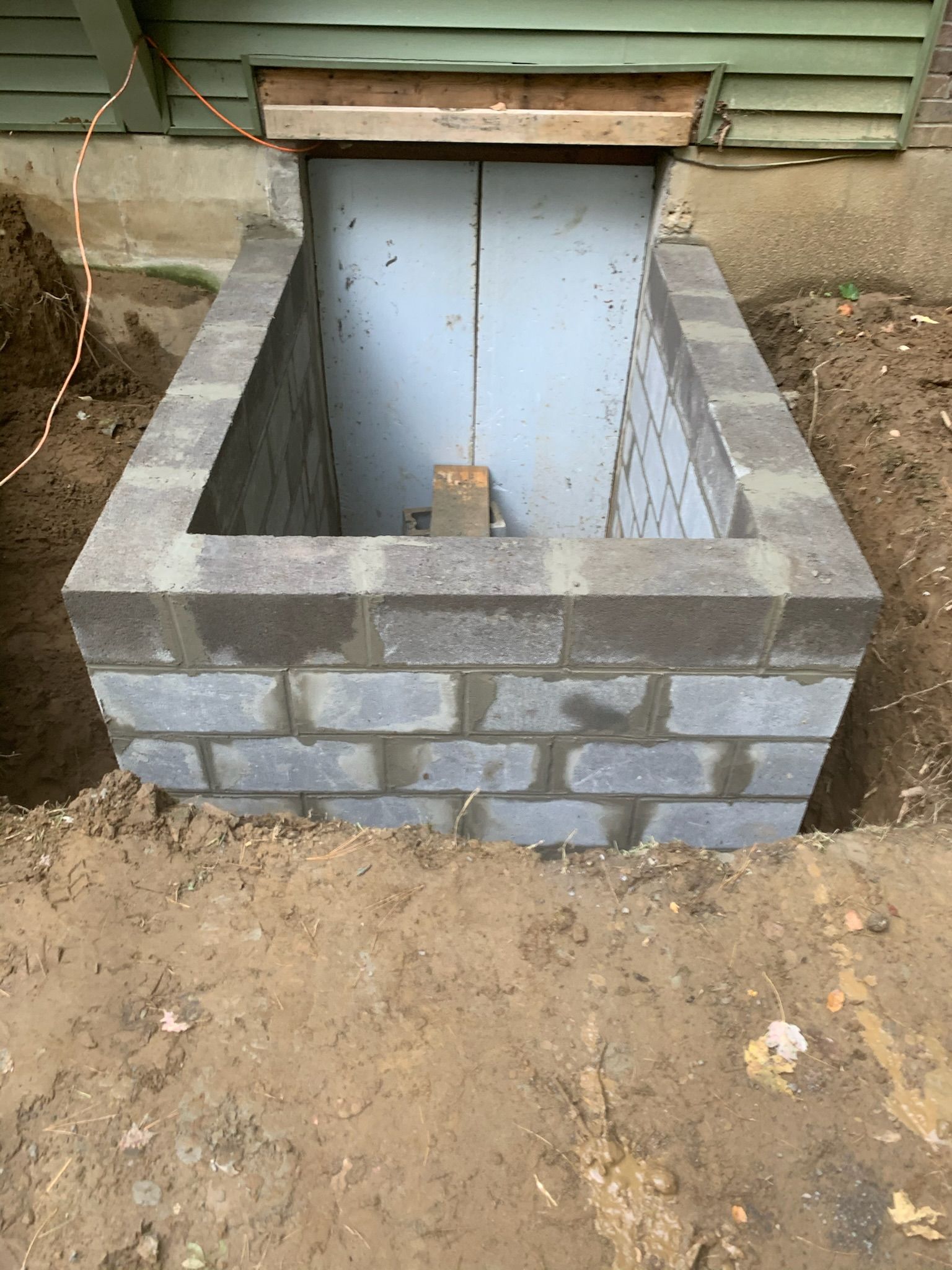A house is covered in plastic while being painted.