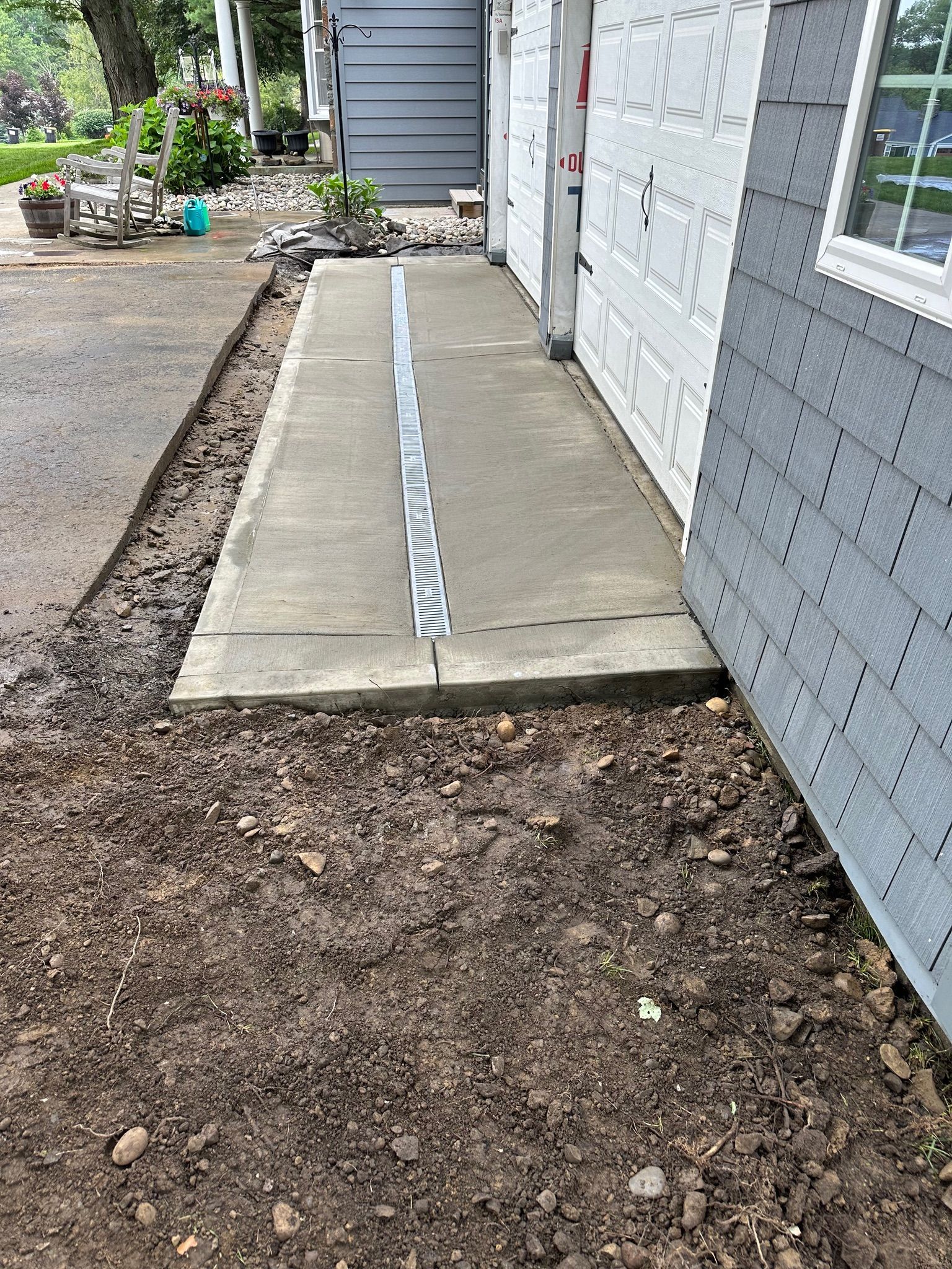 A concrete walkway is being built in front of a house.