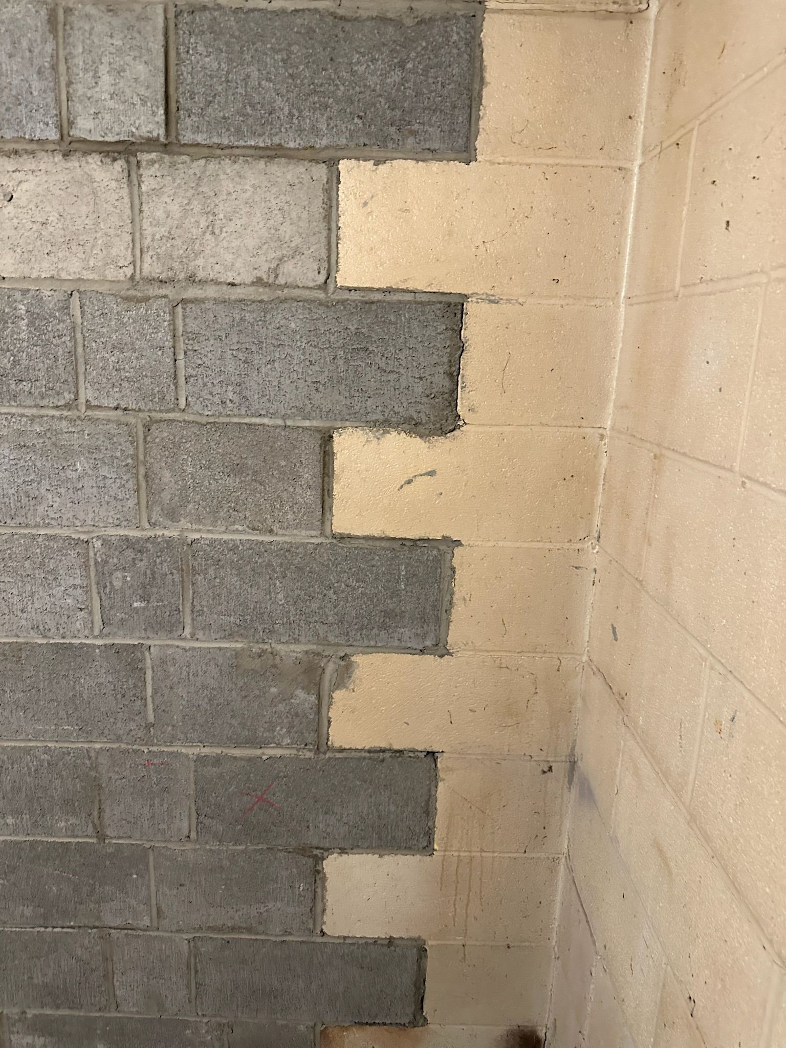 A corner of a brick wall with a few bricks missing