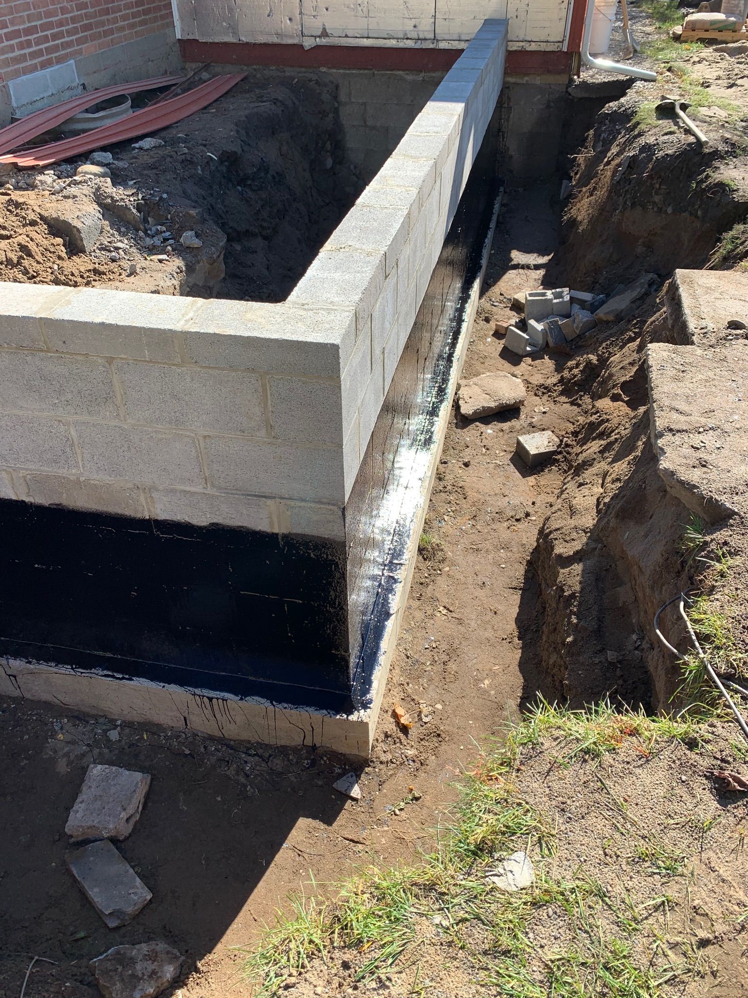 A concrete wall is being built around a hole in the ground.