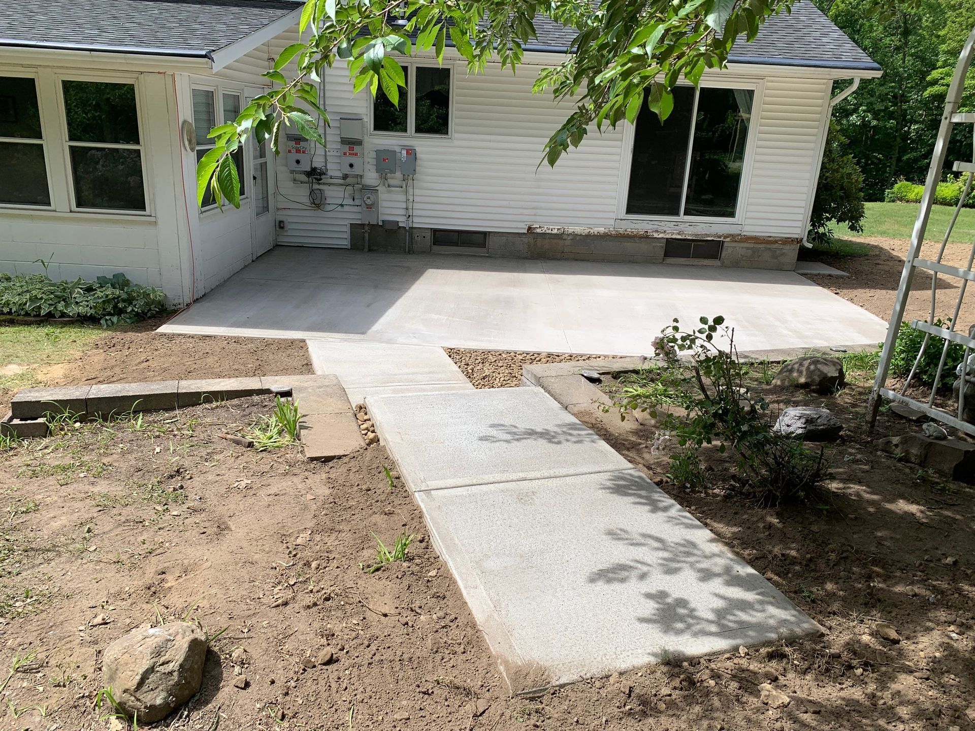 A white house with a concrete walkway leading to it.
