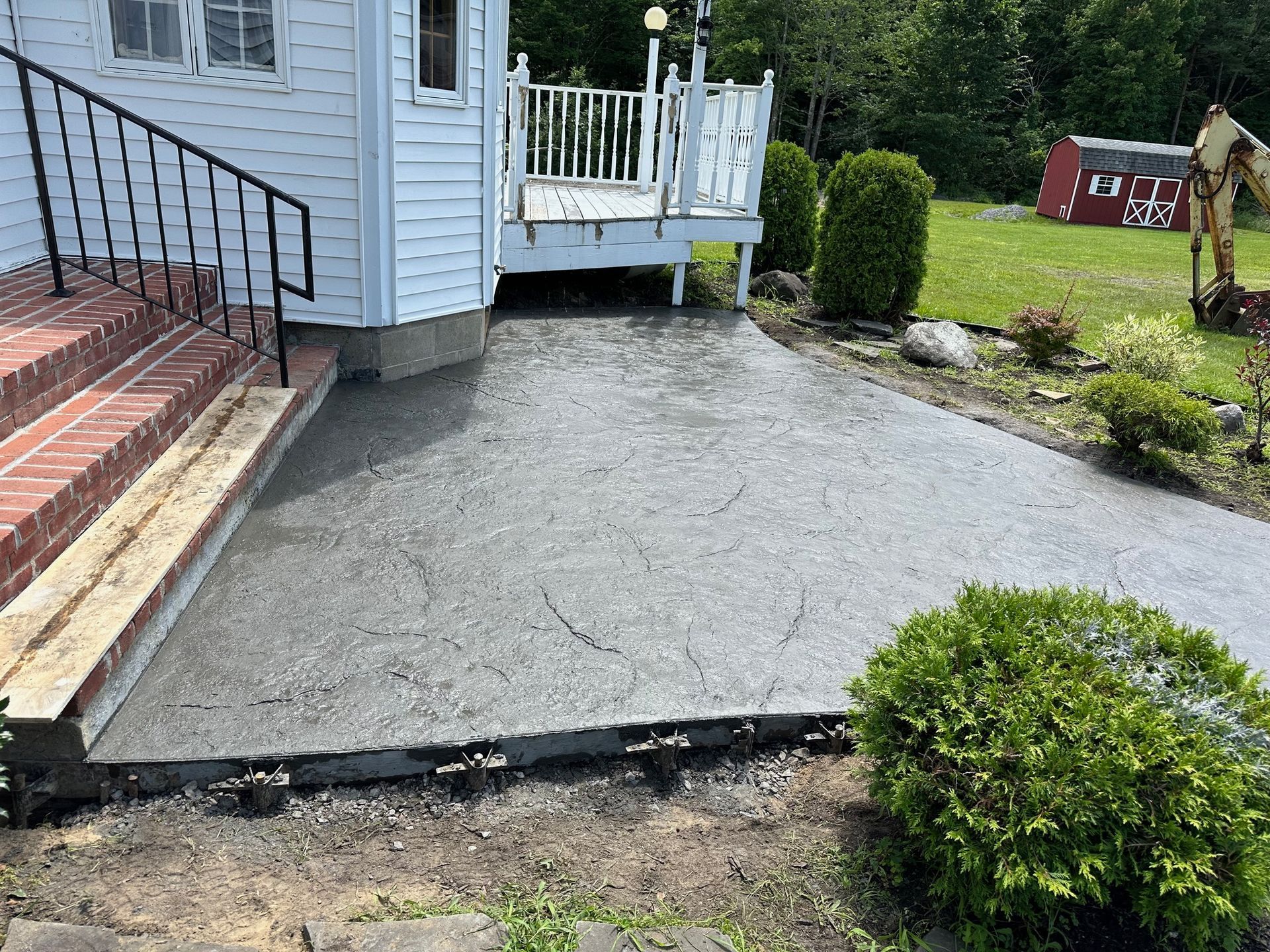 A concrete walkway is being built in front of a house.