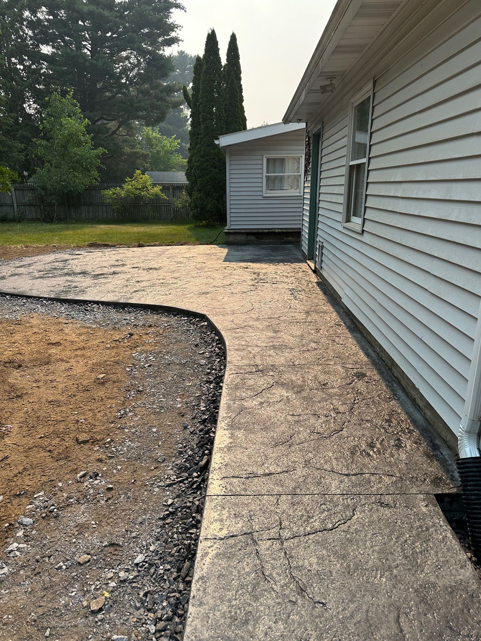 A white house with a concrete walkway leading to it.
