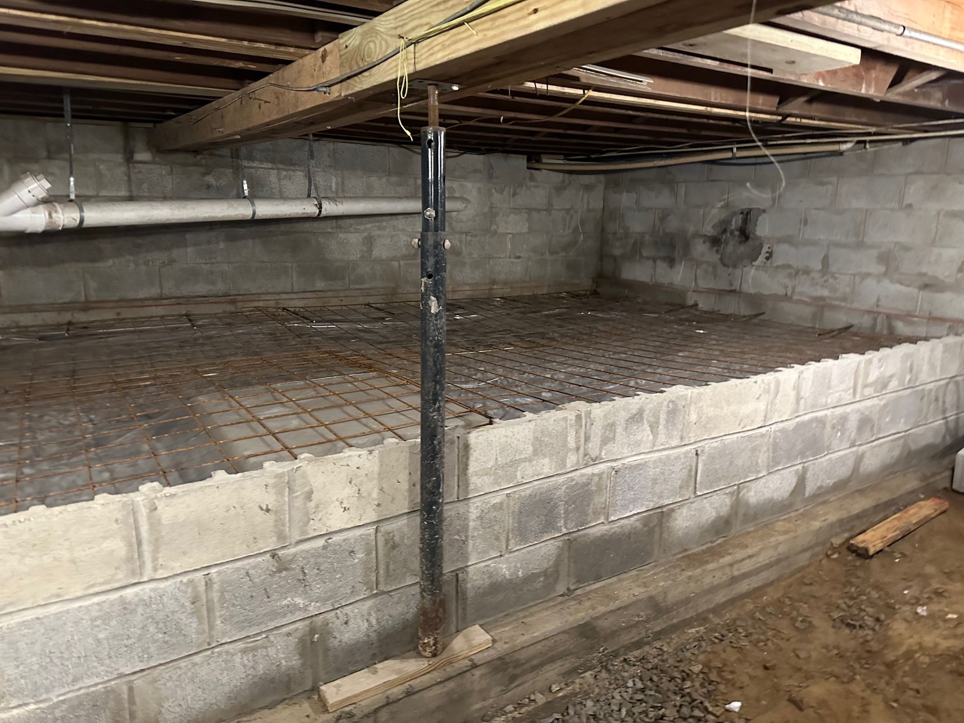 A basement with a concrete floor and a brick wall