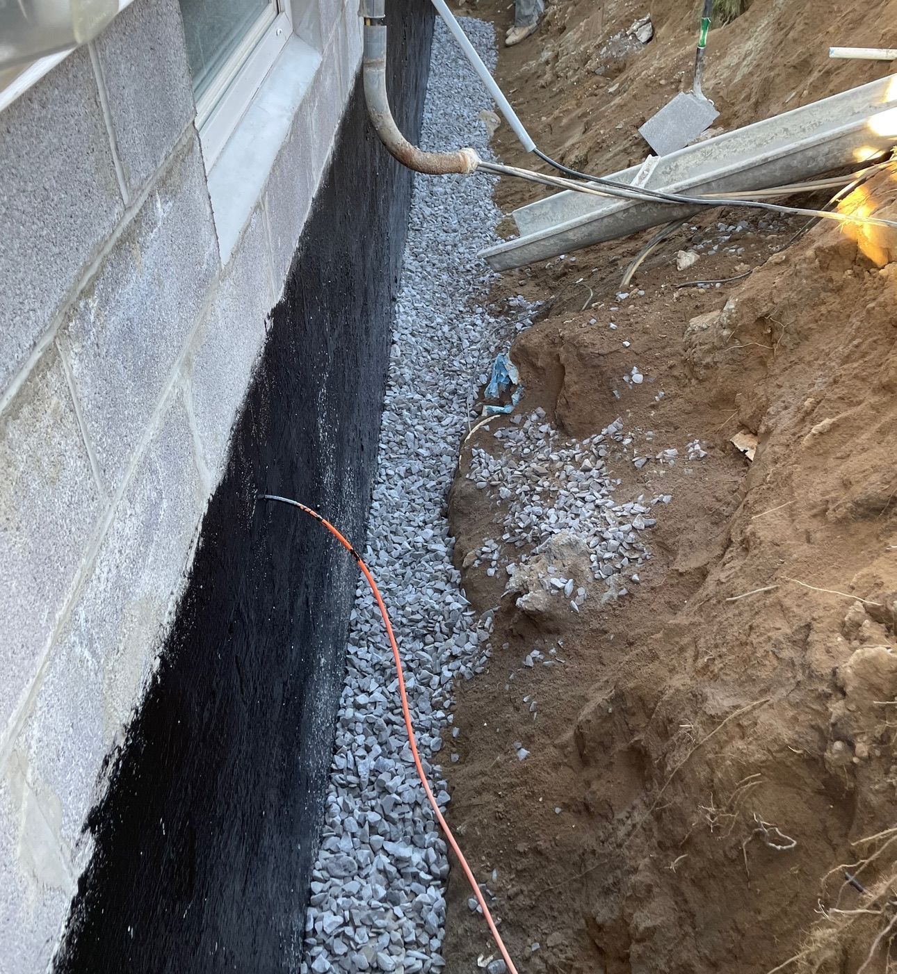 A drainage system is being installed on the side of a building