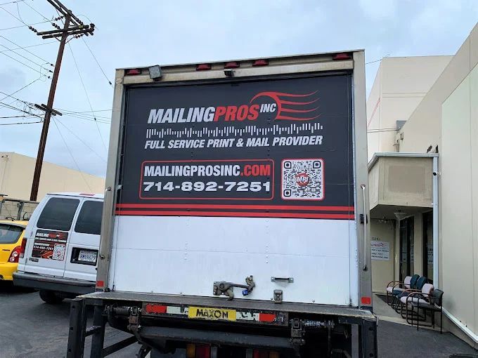 Back of a truck with a Mailing Pros Inc. advertisement on a loading dock.