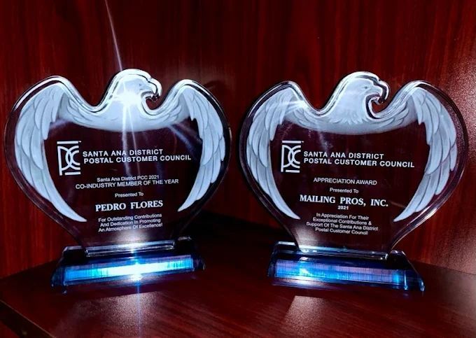 Two glass eagle-shaped awards. Left reads 