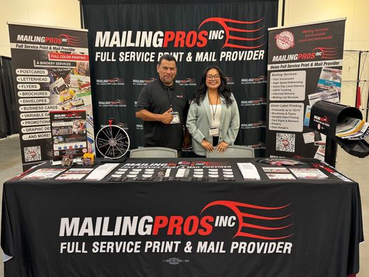 Two people stand behind a booth for 