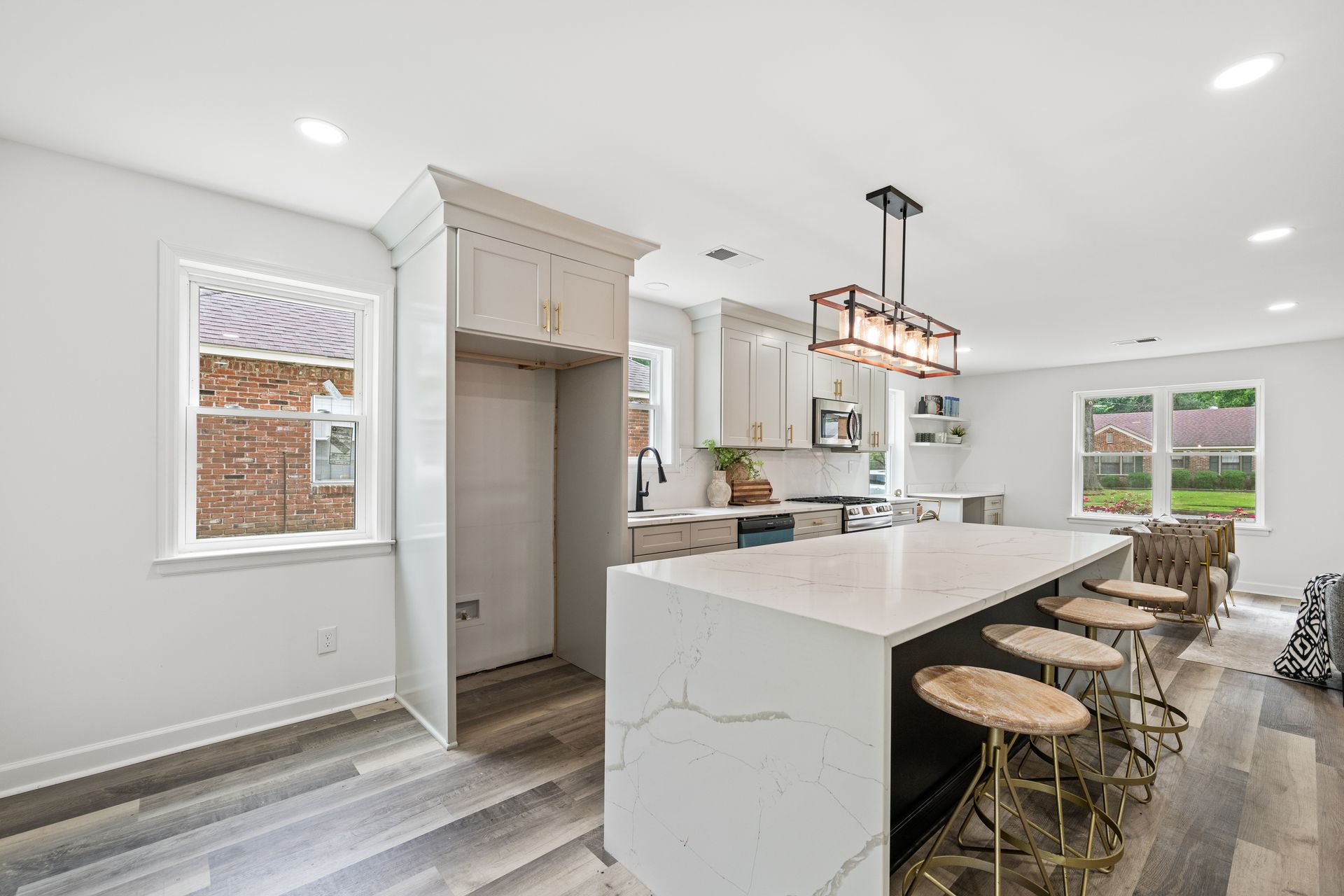 Modern kitchen with white cabinets, island, and wood floors.