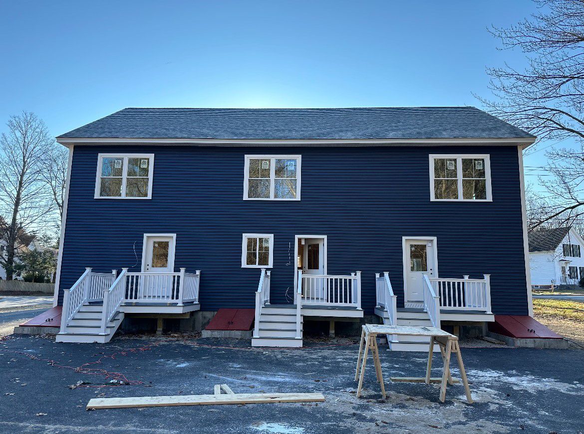 A blue house with white trim is being built.