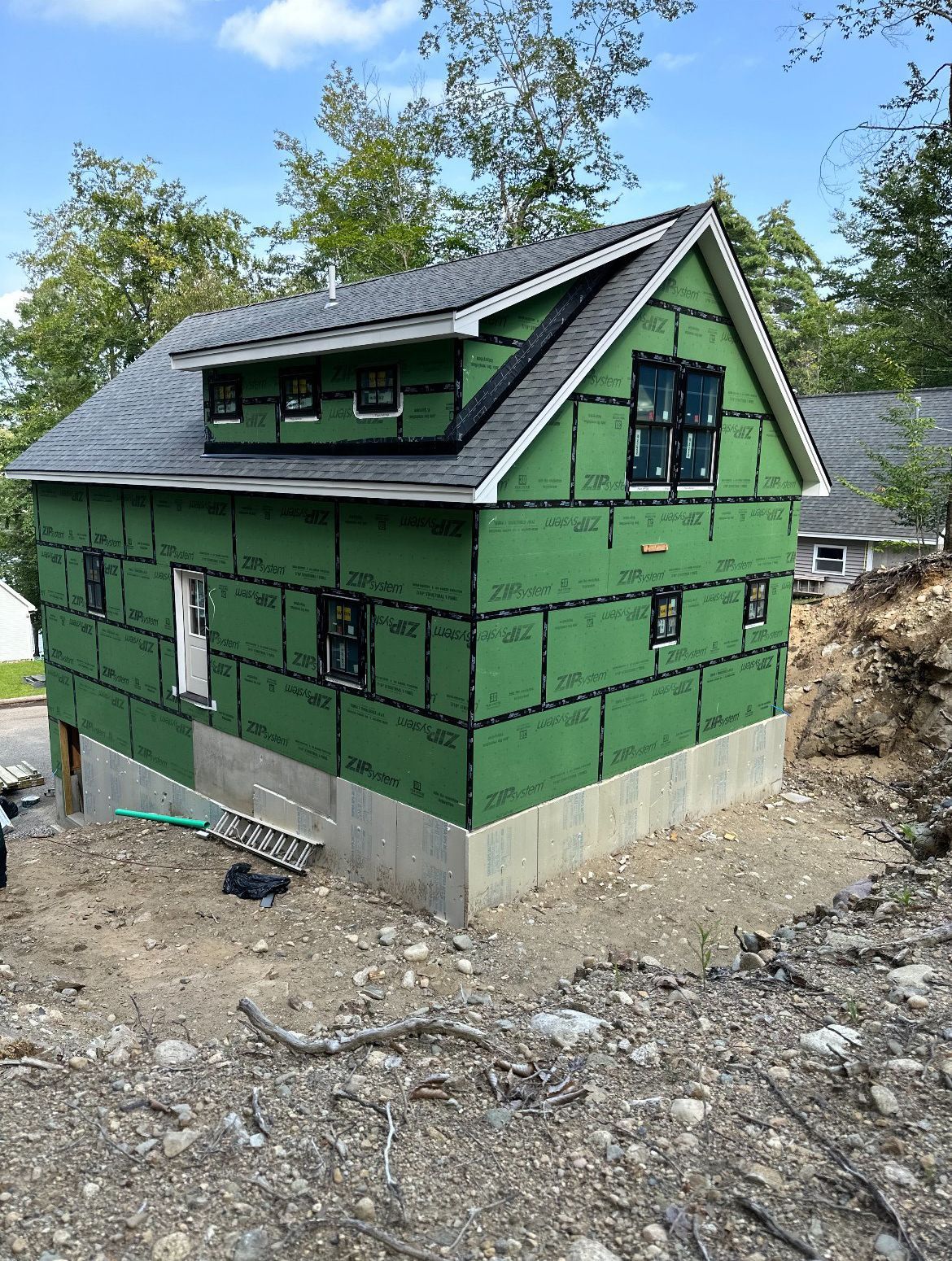 A small house is being built on top of a dirt hill.