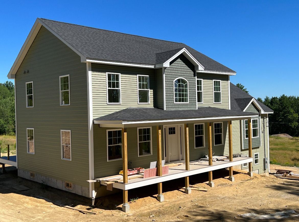 A large house with a porch is under construction