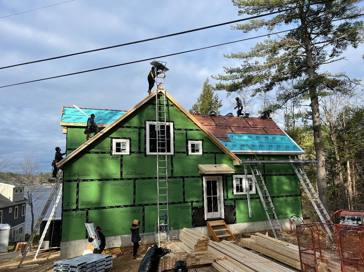 A group of people are working on the roof of a house.