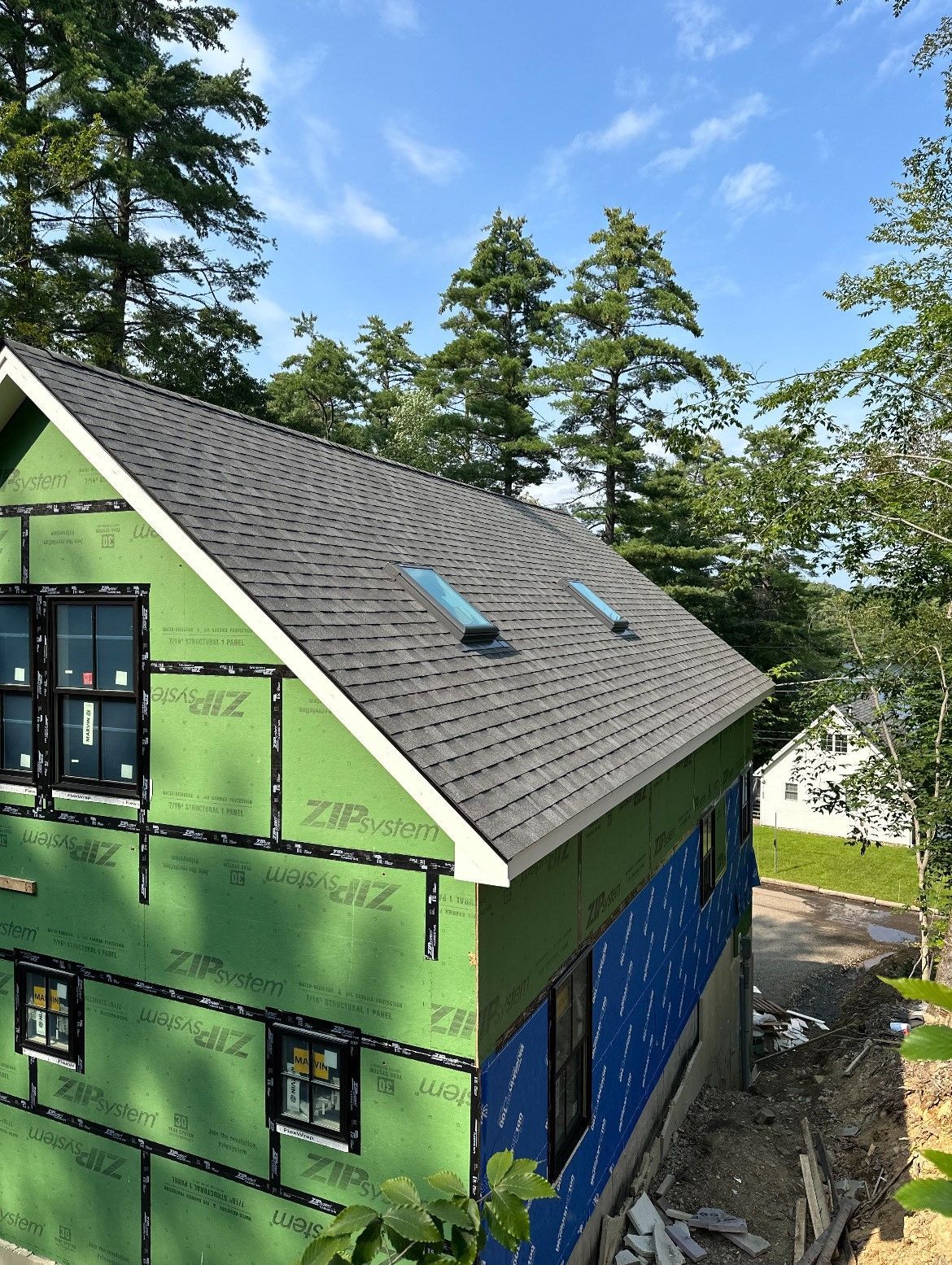 A house under construction with a roof that has a skylight on it.