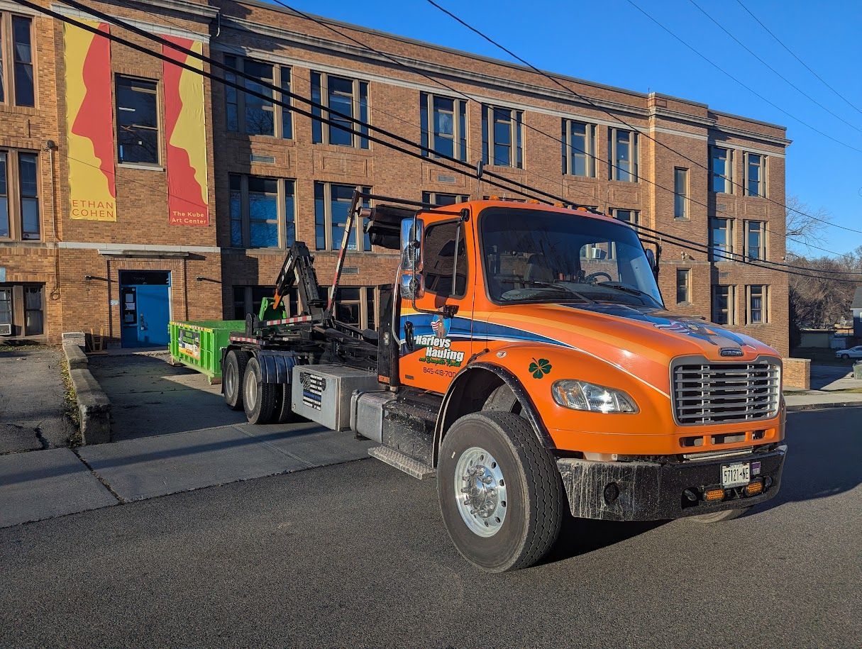 Orange tow truck parked beside a brick building on a city street