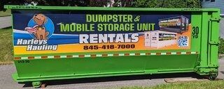 Green dumpster trailer with Harley’s Hauling and dumpster rental business signage