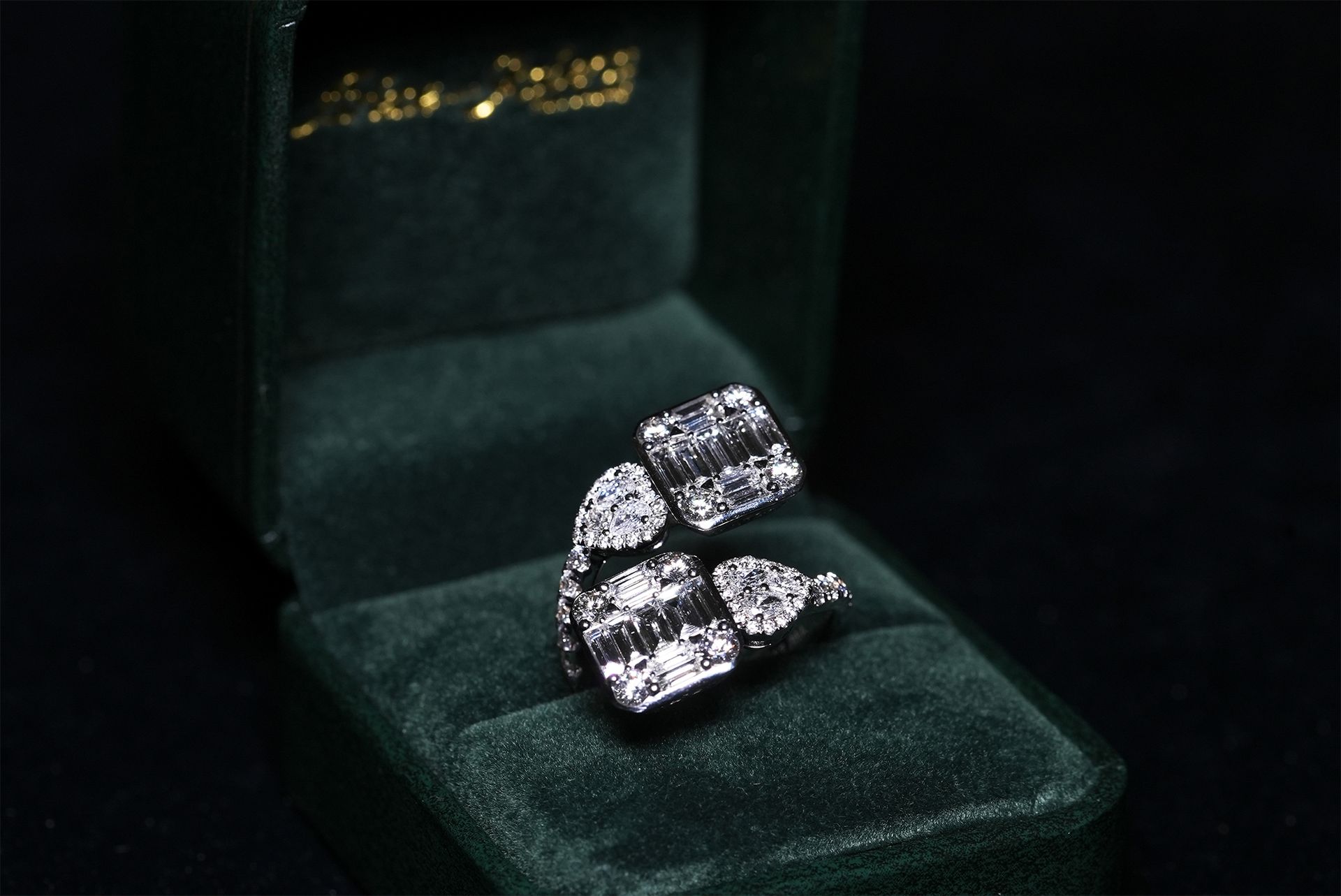 Diamond ring in a green velvet jewelry box.
