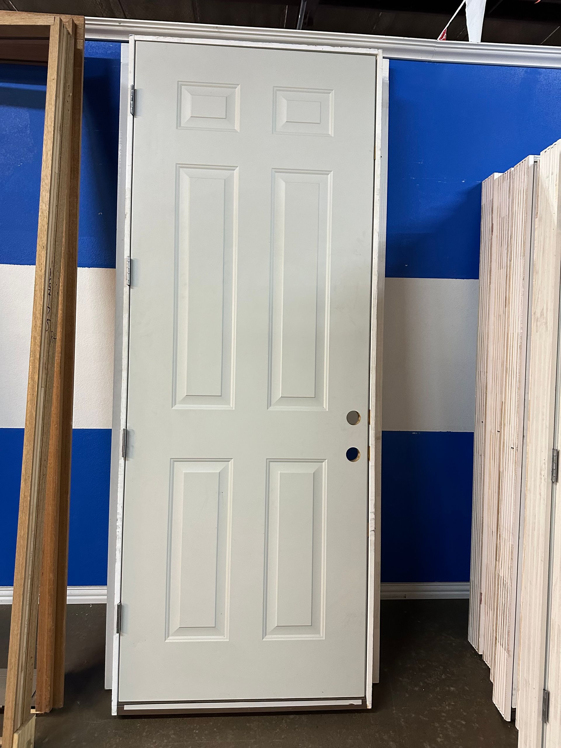 A white door is sitting in front of a blue and white wall