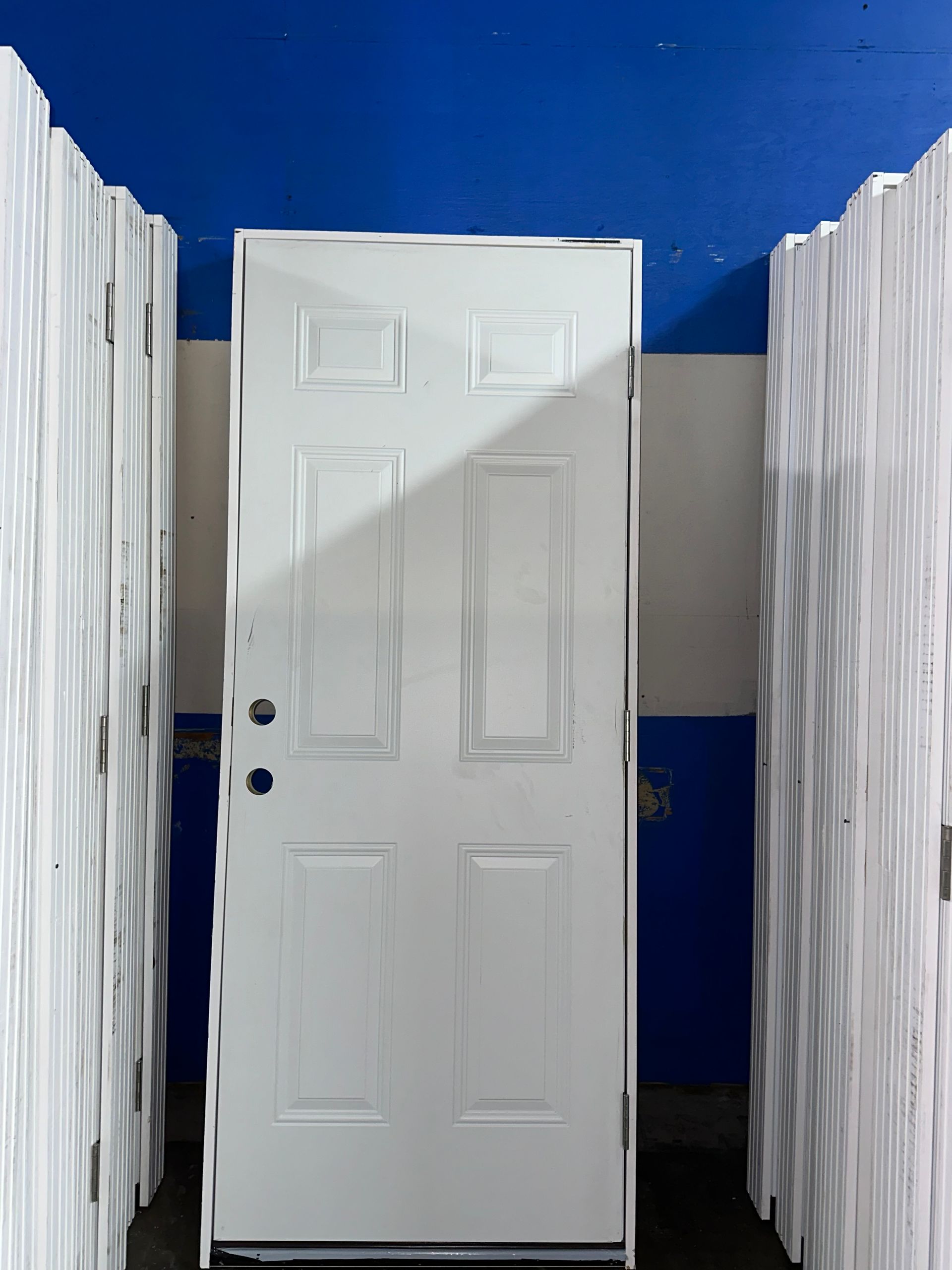 A white door in a room with a blue wall