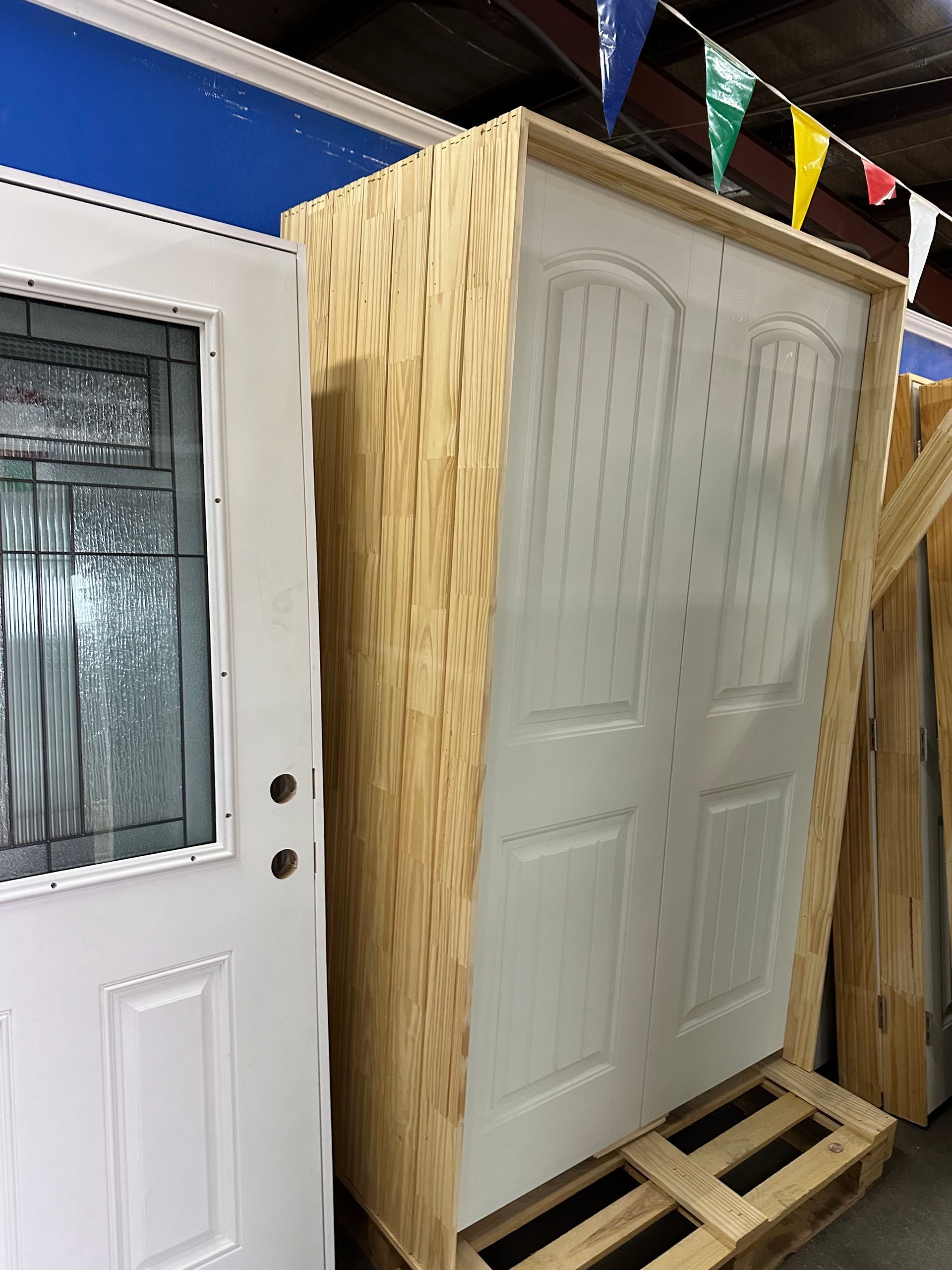 A white door is sitting on top of a wooden pallet.