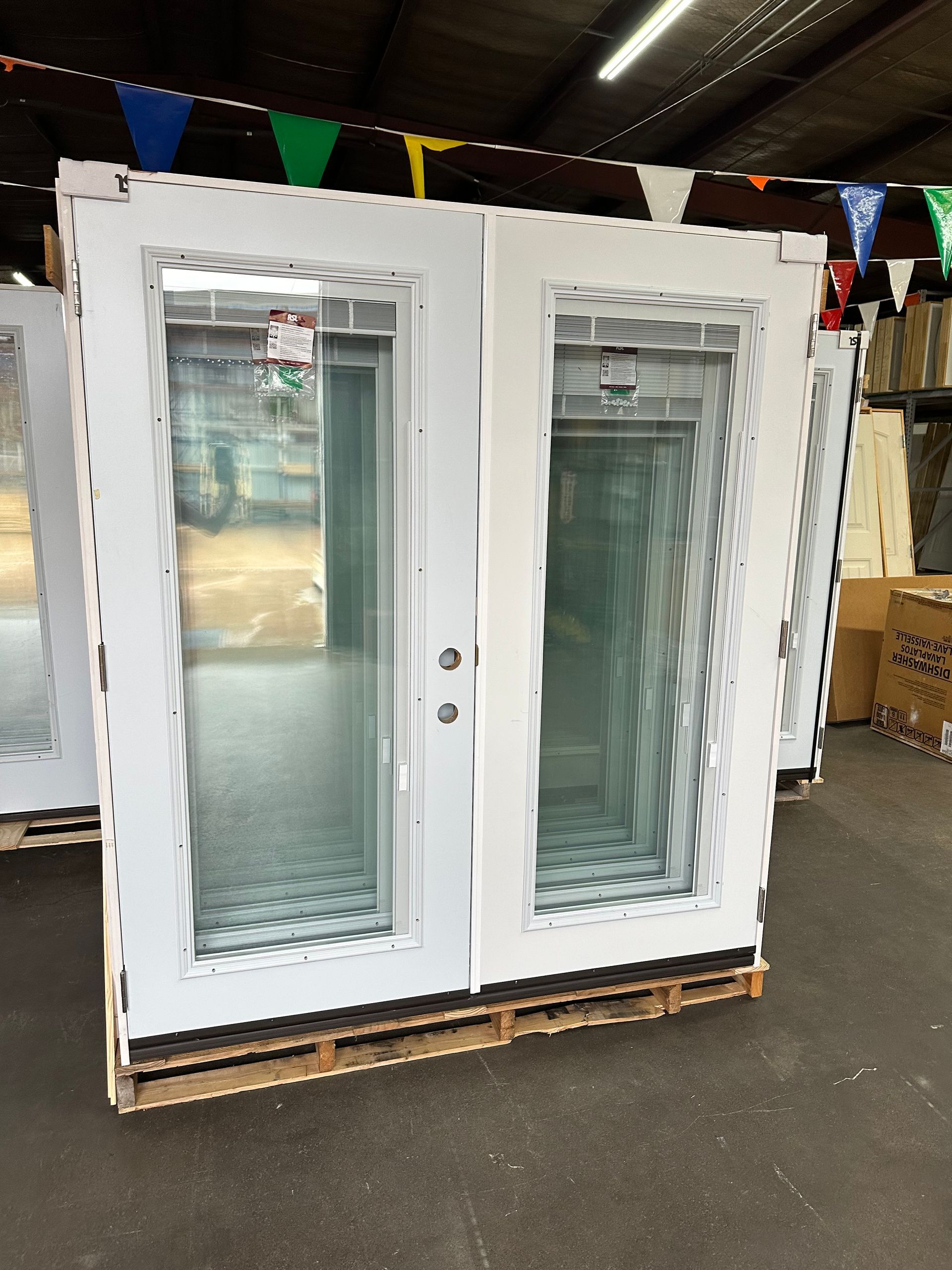 A pair of white doors are sitting on a wooden pallet