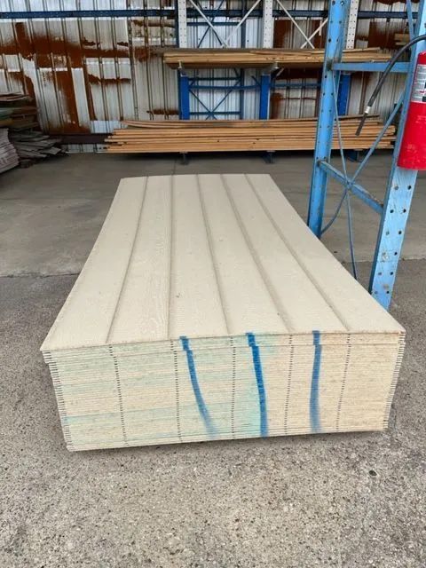 A stack of plywood is sitting on the ground in a warehouse