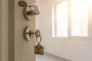 Close up of a house key in the front door of a rental apartment that is being neglected by the landlord