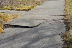 Cracked, broken sidewalk which is a hazard that could cause an injury that falls under premises liability