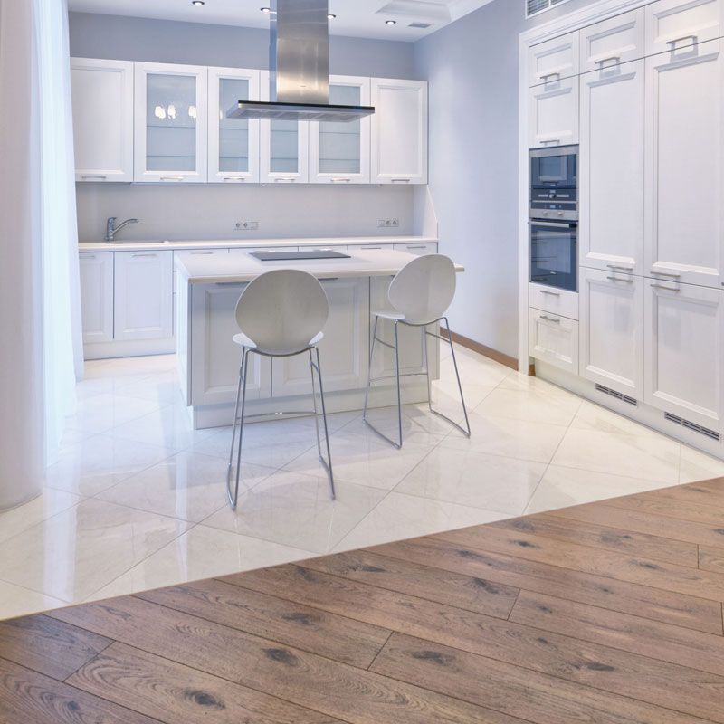 a kitchen with white cabinets and wooden floors