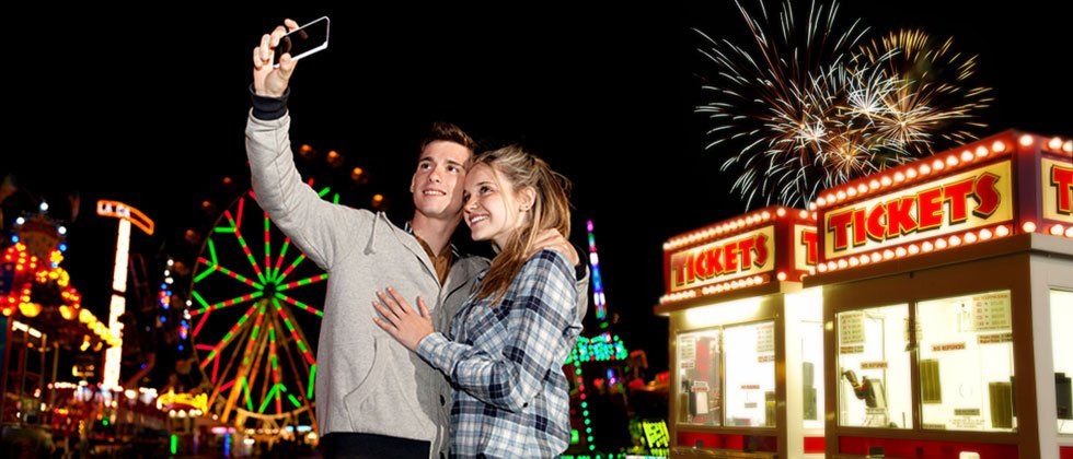 Couple taking a picture at a carnival using a smart phone