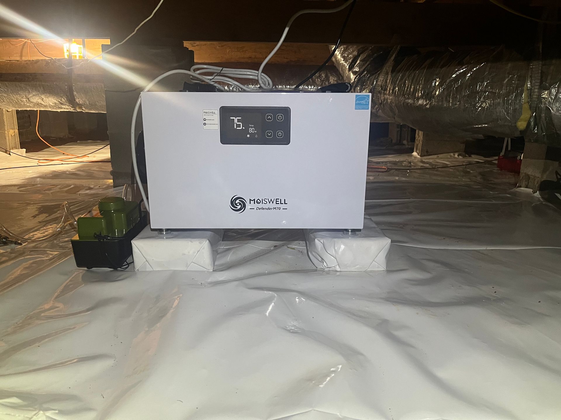 A white box is sitting on top of a white plastic sheet in a room.