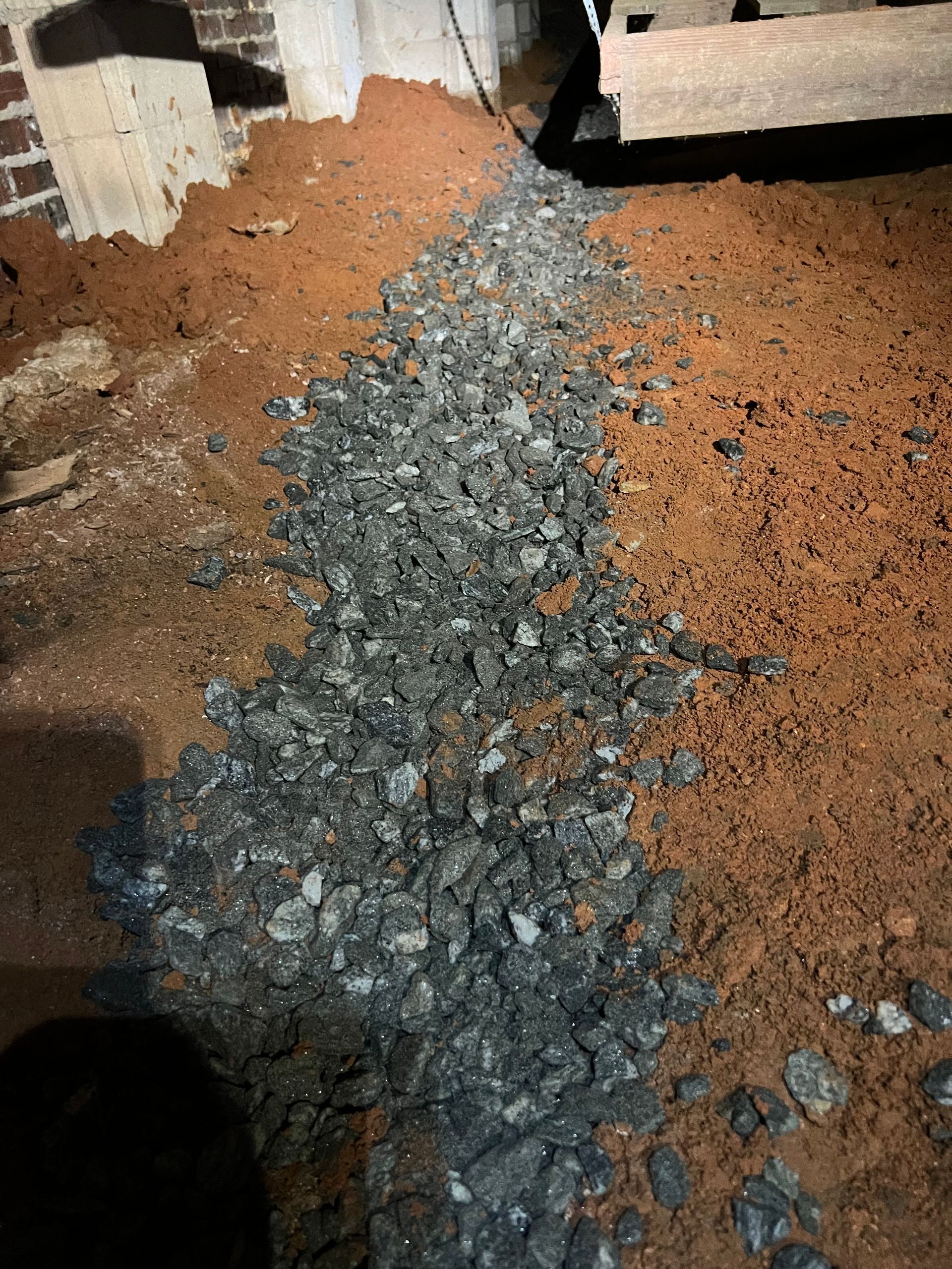 A pile of rocks and dirt on the ground in a basement.