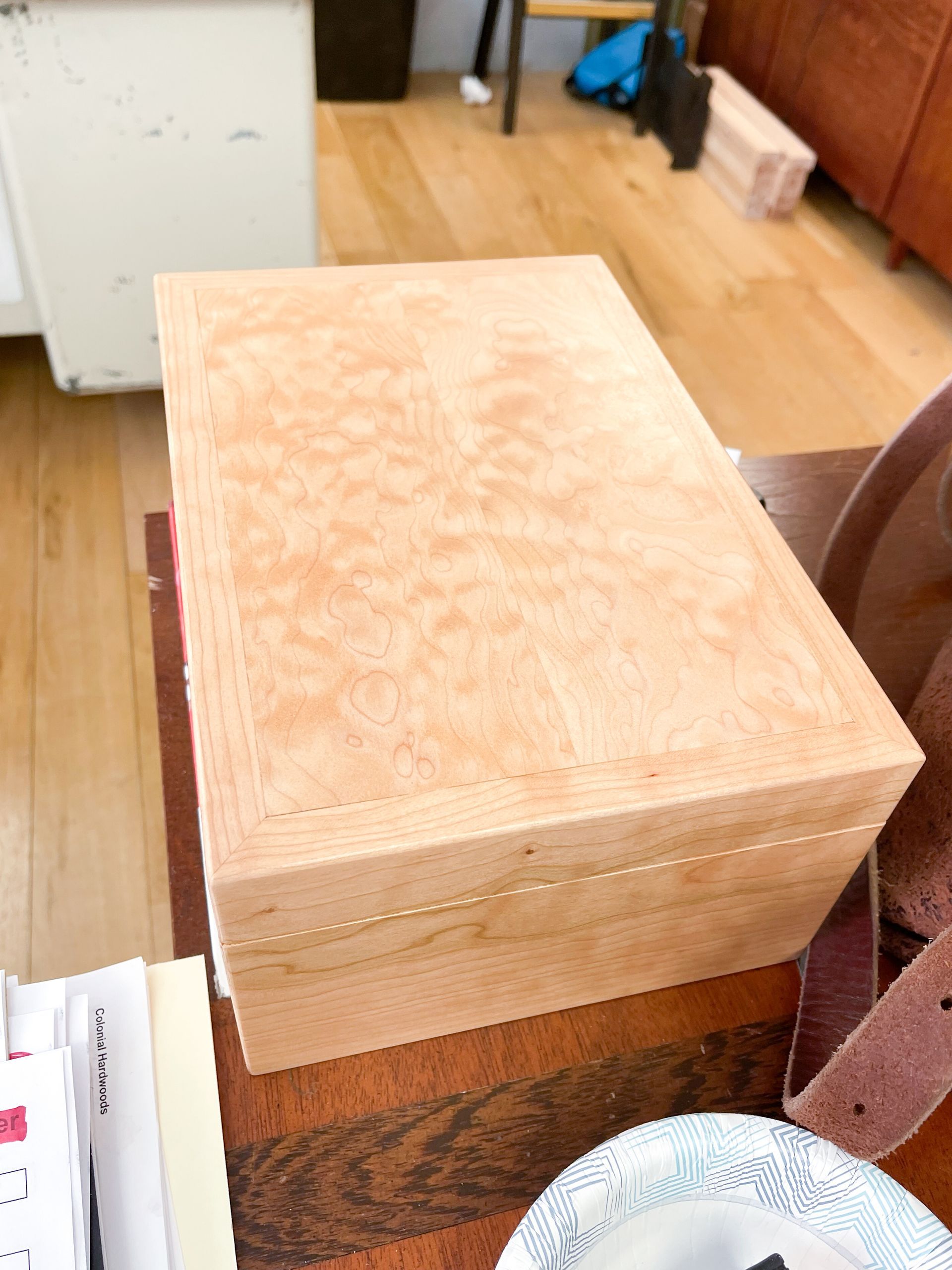 Wooden box with a patterned top on a wooden table.