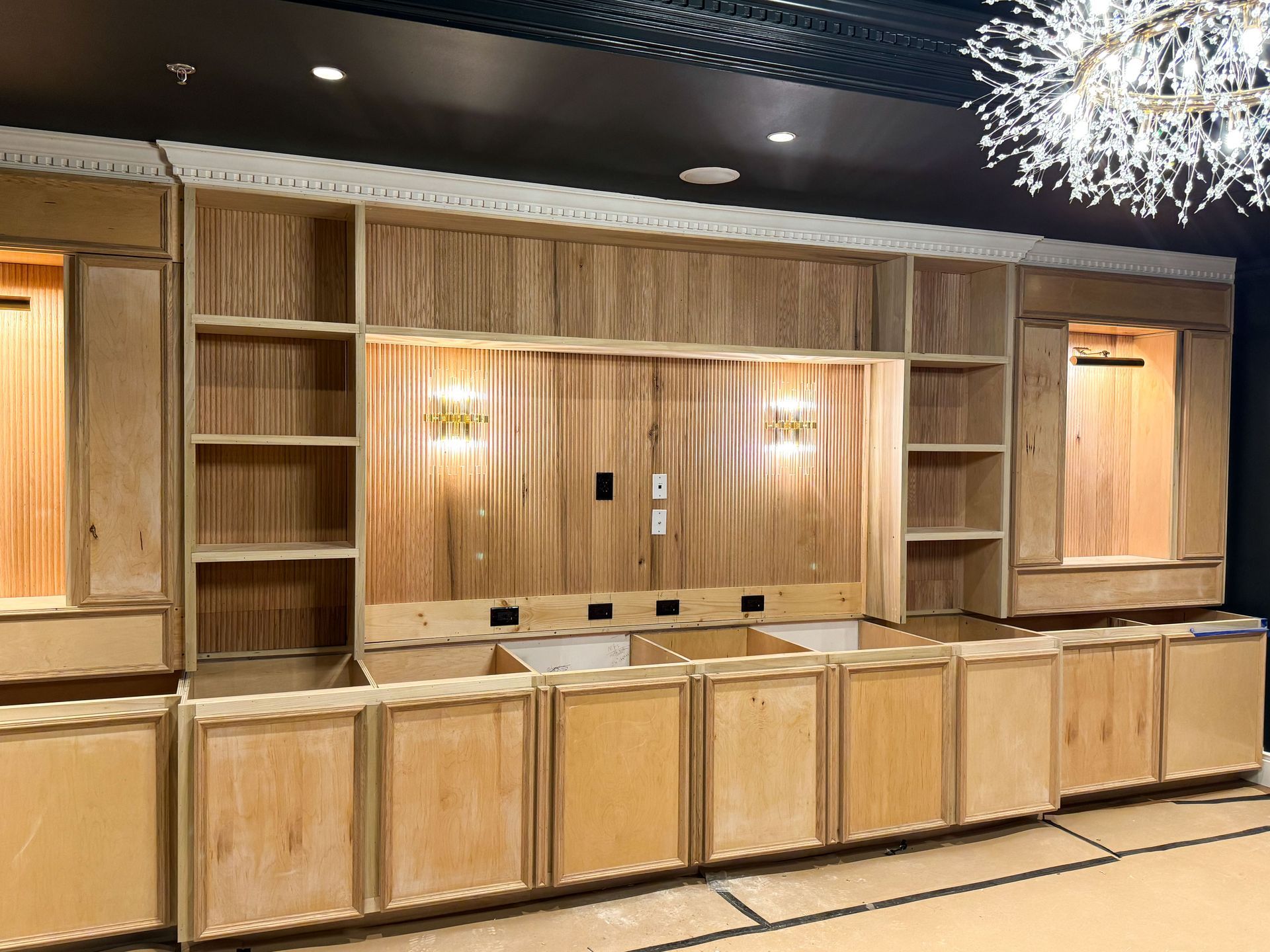 Wooden built-in shelving and cabinets with unfinished wood, and recessed lighting.