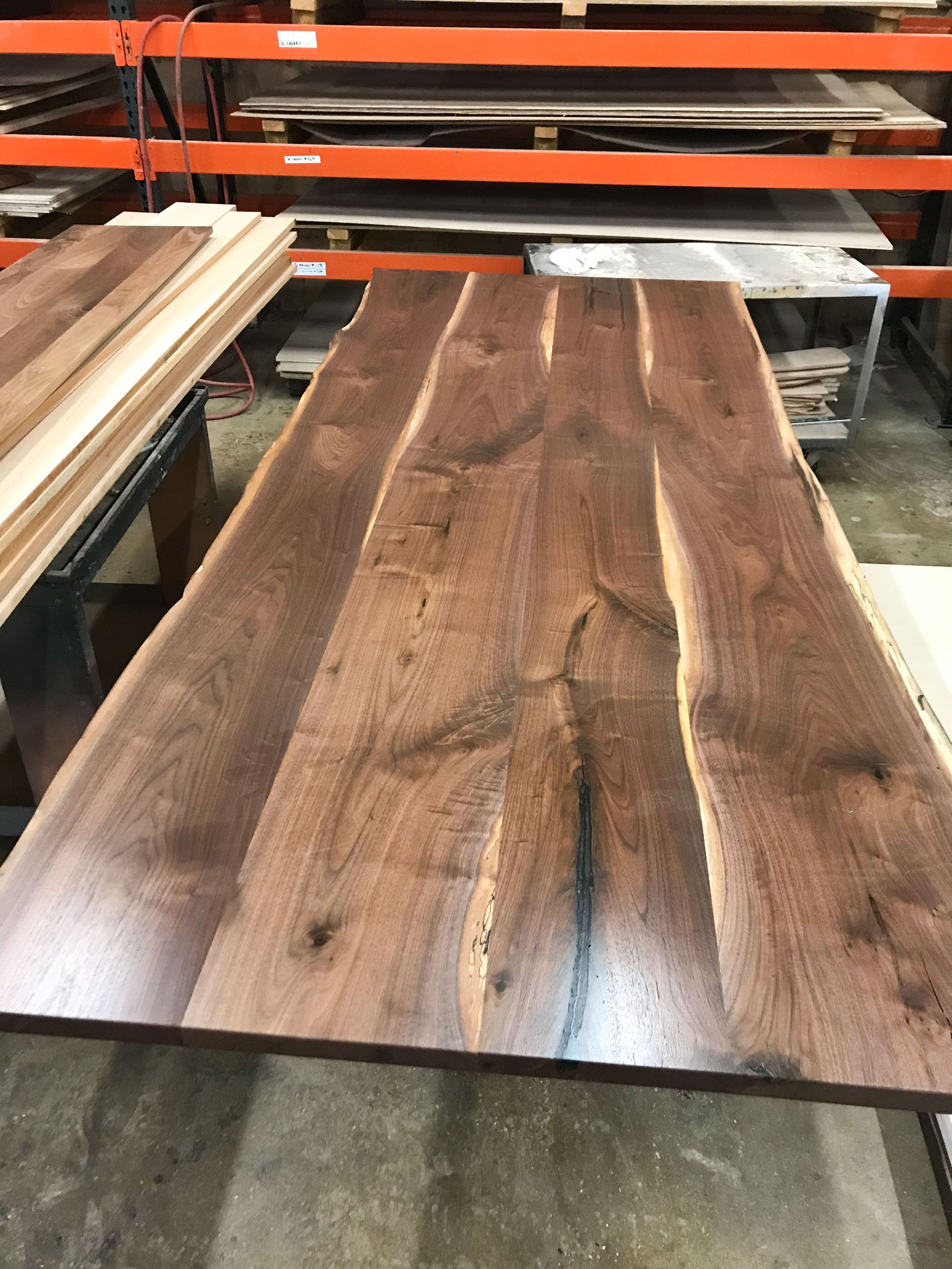 Wooden slab, likely a tabletop, with dark brown grain, indoors.