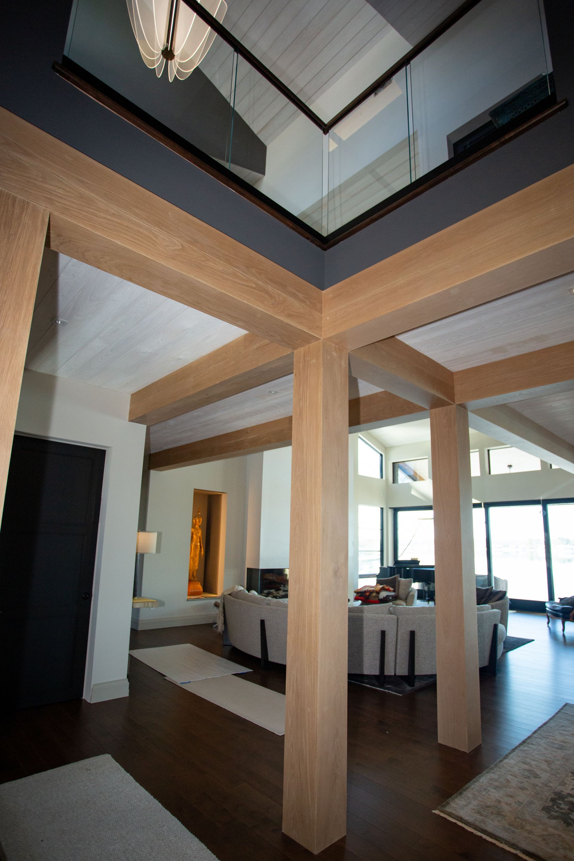 Interior with wooden beams, dark floor, and a mirrored ceiling, showing an open space design.