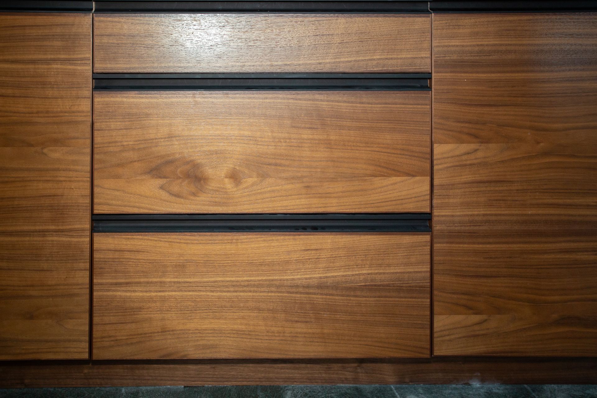 Wooden cabinet with two drawers and two doors; black horizontal handles.