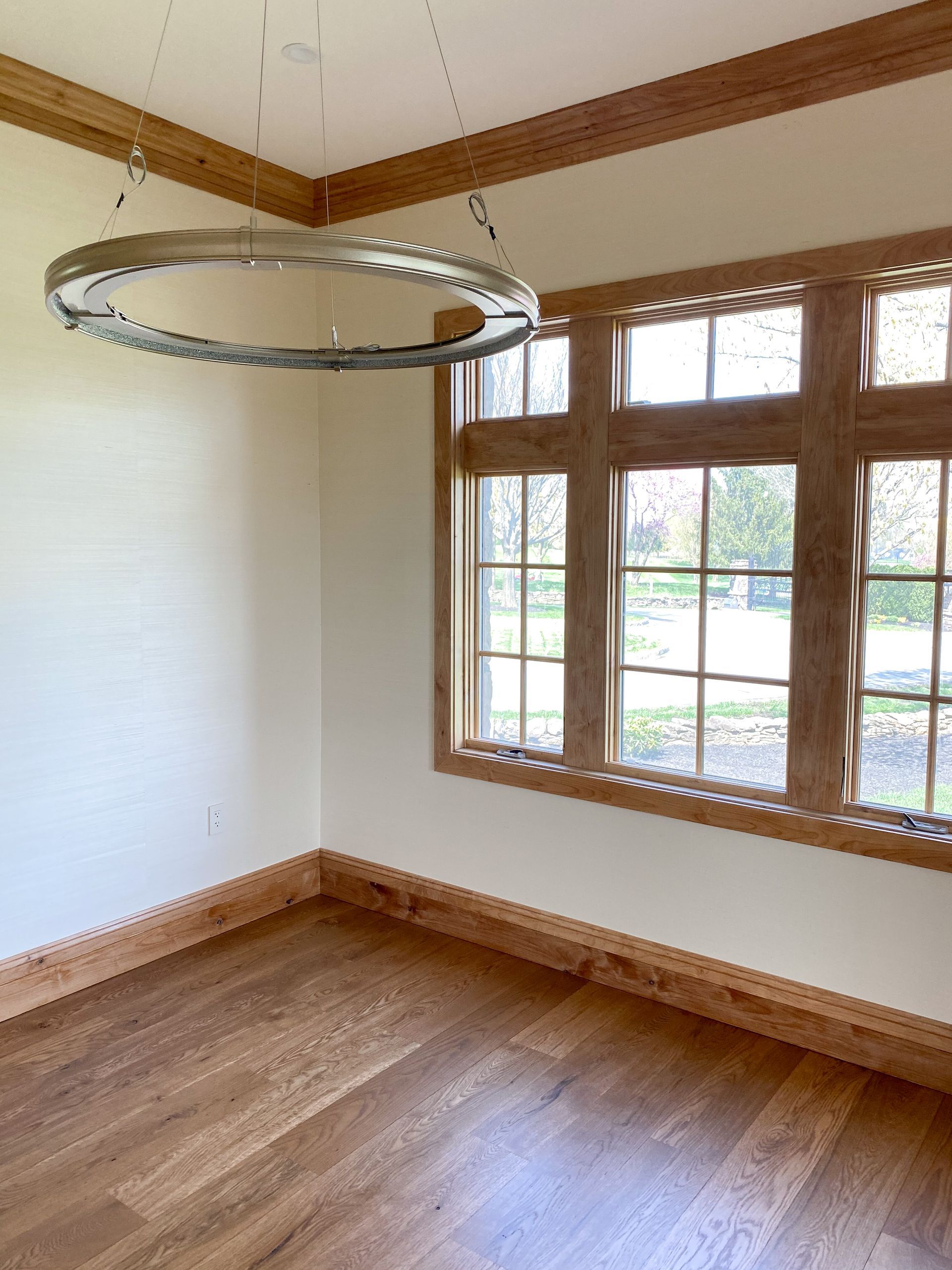 Room with wood trim, large window, and circular light fixture.