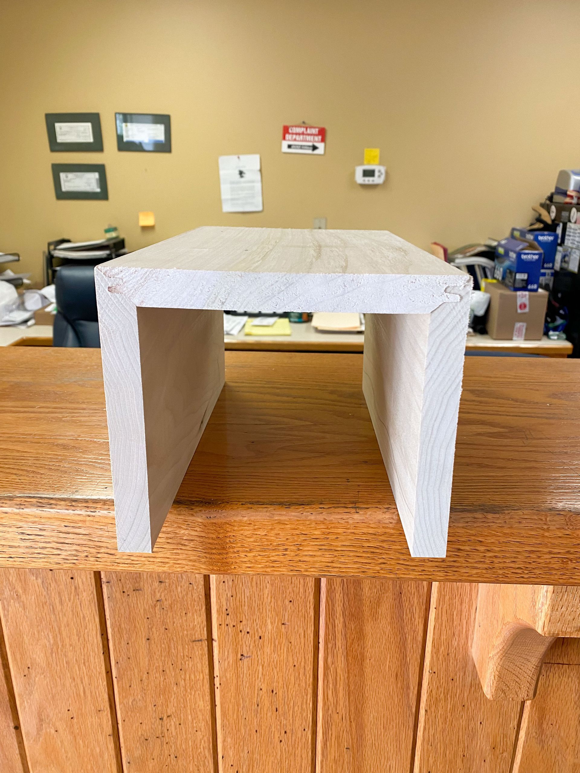 A light-colored, U-shaped piece of stone or composite material on a wooden surface.