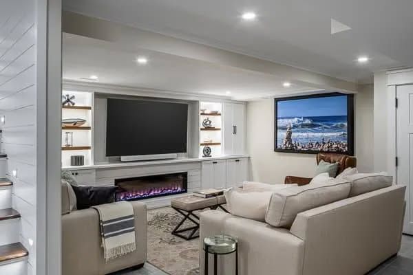 Modern living room with white sectional sofas, a wall-mounted TV, fireplace, and city-view artwork