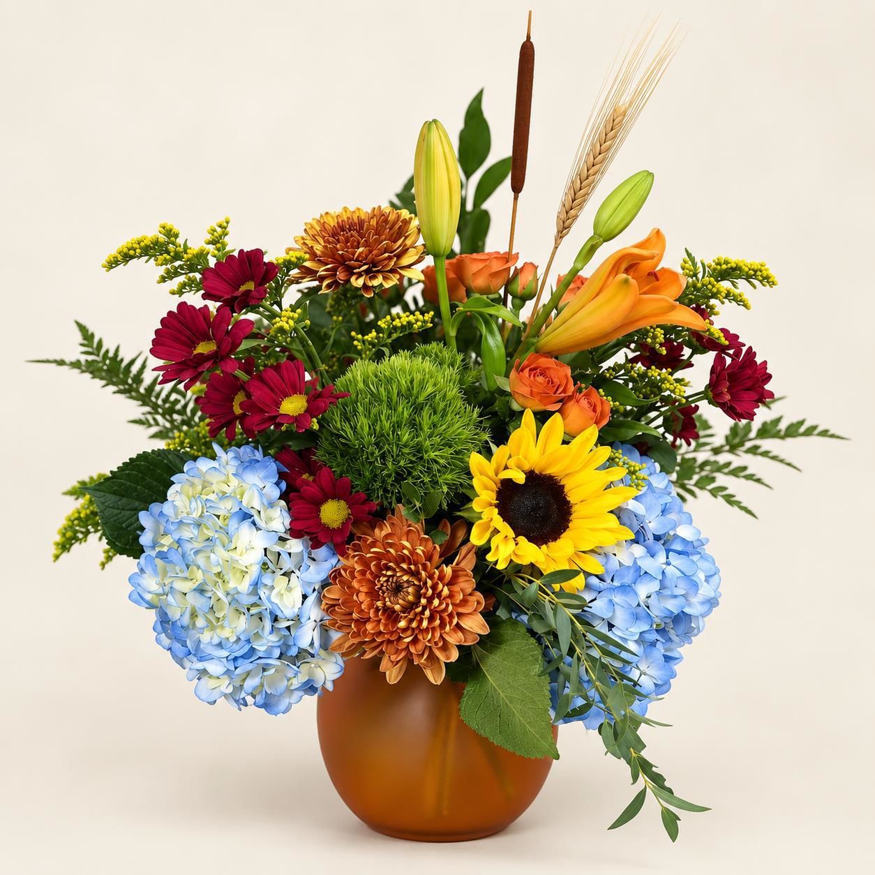 Colorful mixed bouquet in a brown vase with sunflowers, hydrangeas, and orange lilies on a light background