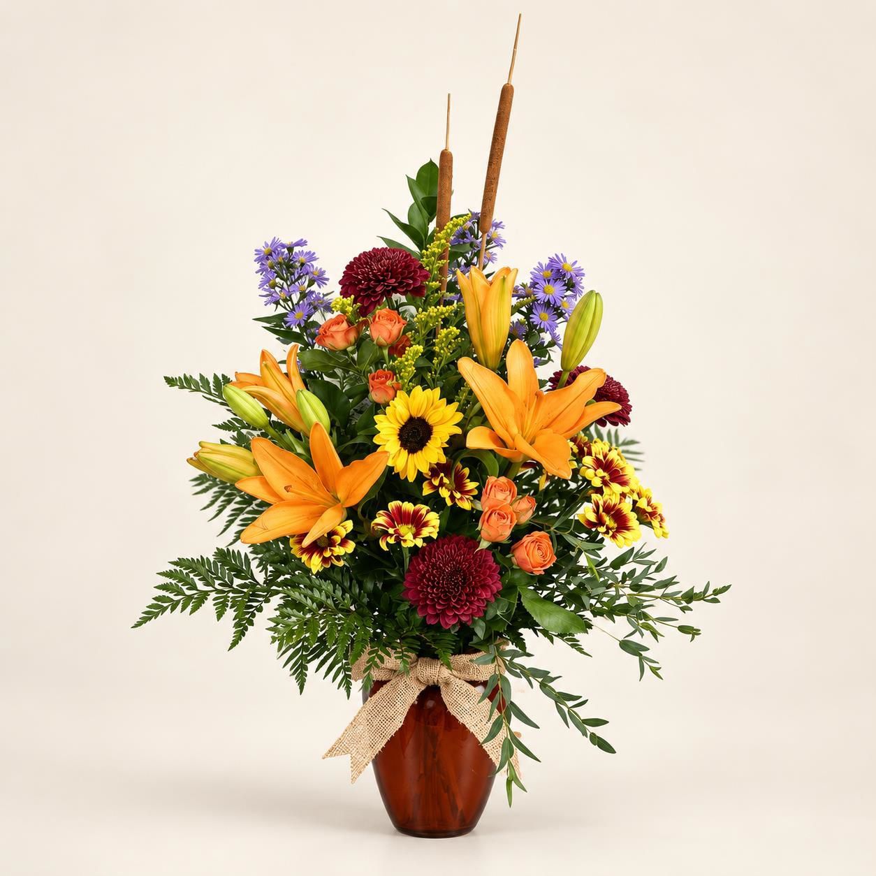 Colorful floral arrangement in a brown vase with lilies, sunflowers, and purple blossoms