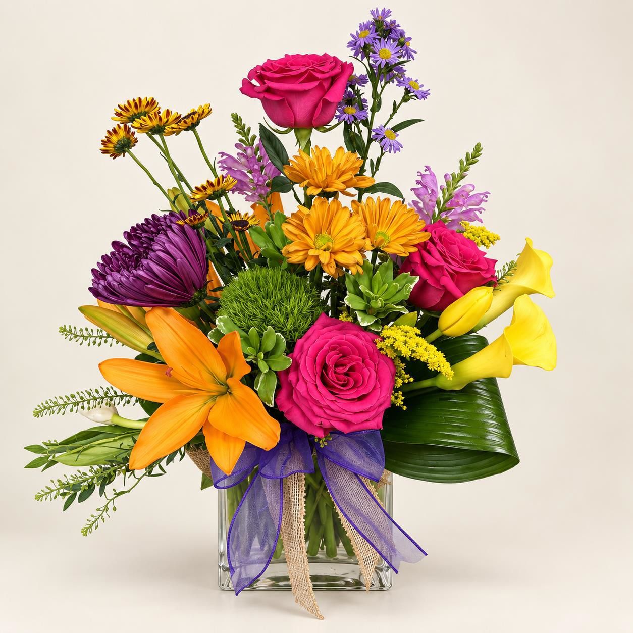 Colorful mixed bouquet with roses, lilies, and purple flowers in a vase, tied with a purple ribbon