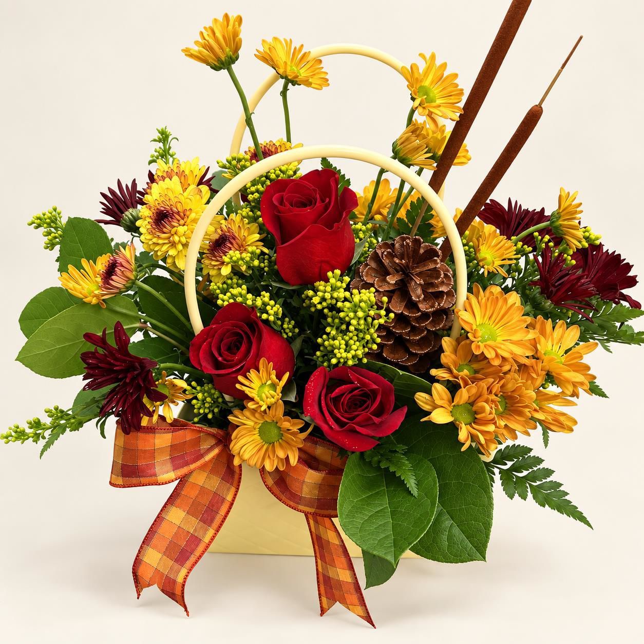 Autumn floral basket with red roses, yellow flowers, pinecone, and plaid ribbon