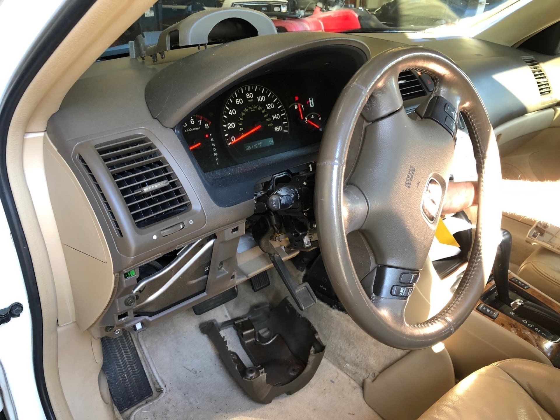 A white car with a broken steering wheel and dashboard