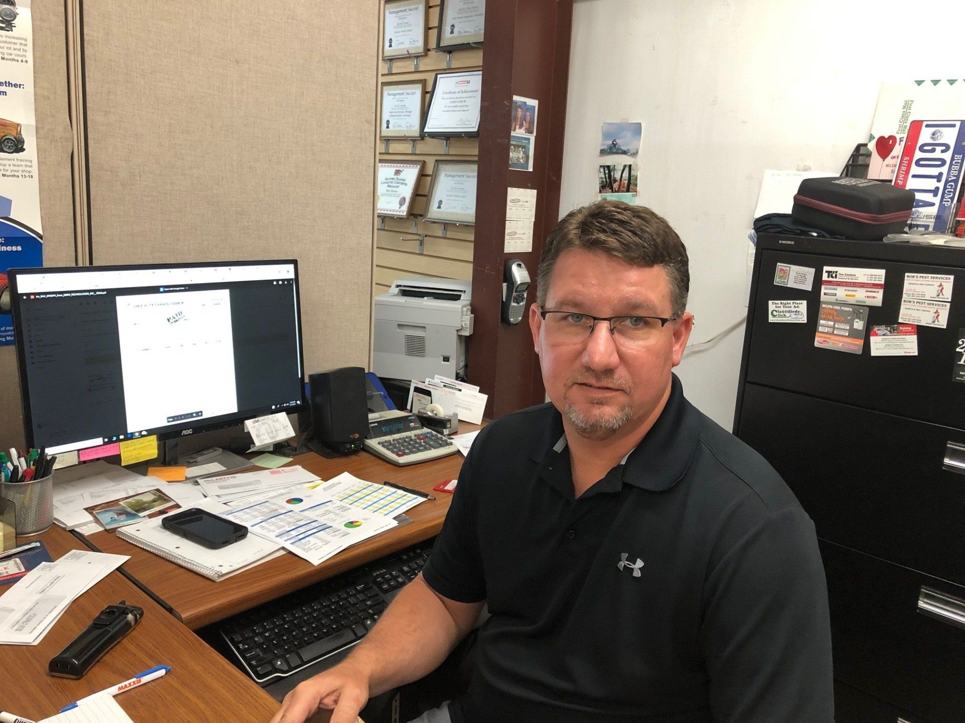 A man is sitting at a desk in front of a computer.