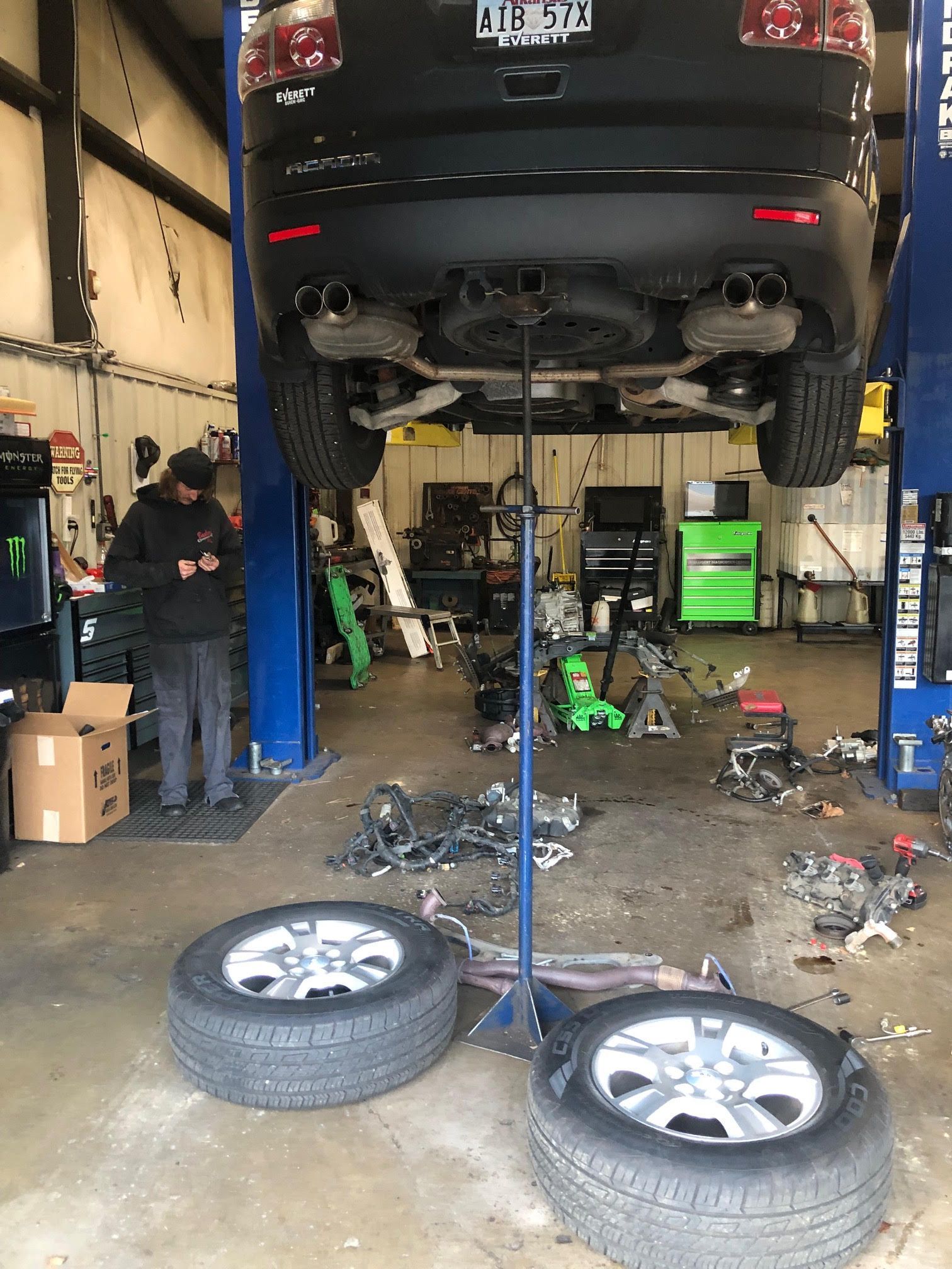 A car is sitting on a lift in a garage.
